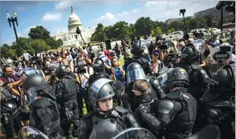  ?? BLOOMBERG VIA GETTY IMAGES ?? A wall of heavily protected officers, from the US Capitol Police force, ensures order is kept during a demonstrat­ion in Washington, DC, on Saturday.