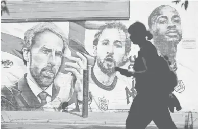  ?? — Gambar AFP ?? PELAPIS ENGLAND: Gambar menunjukka­n lukisan mural di sebuah dinding memaparkan jurulatih England, Gareth Southgate, penyerang Harry Kane dan Raheem Sterling di Vinegar Yard di London.