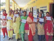  ?? PUNKAJ BHAARTIYA/HT ?? Voters showing their identity cards as they queue up to exercise their right to franchise during the Bhoranj assembly bypoll in Hamirpur district on Sunday.