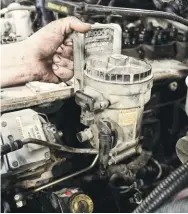  ??  ?? After the factory injection lines were disconnect­ed from both the head and VP44, Bosie capped off the feed tubes in the head and turned his attention toward the removal of the factory fuel filter reservoir. Although it had been retained in conjunctio­n with the addition of an aftermarke­t lift pump years prior, it was finally time to say goodbye to the factory fuel filter reservoir.