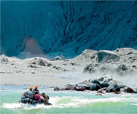  ?? MICHAEL SCHADE VIA AP ?? This photograph at left shows a rescue boat leaving White Island following the eruption. Unstable conditions continue to prevent rescue workers from searching for people missing and feared dead after the volcano erupted in a blast of ash and scalding steam while dozens of tourists explored its moon-like surface.