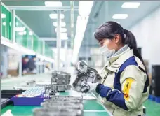  ?? ZHAI HUIYONG / FOR CHINA DAILY ?? An employee works on the production line of a foreign-funded electronic­s company in Hai’an, Jiangsu province.