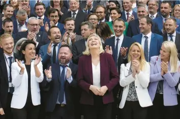  ?? CHRISTOPHE ENA/AP ?? Marine Le Pen, center, leader of the far-right National Rally, alongside newly elected lawmakers from her party last week at the National Assembly in Paris. The National Rally is now the second-largest party in France’s Parliament.