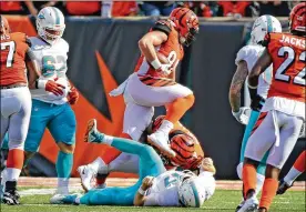  ?? CHARLES TRAINOR JR. / MIAMI HERALD ?? Dolphins quarterbac­k Ryan Tannehill lays on the field as Bengals defensive lineman Sam Hubbard runs the ball back for a 19-yard touchdown Sunday in Cincinnati. The ball came loose on a strip sack by Carlos Dunlap.