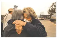  ?? The Sacramento Bee/PAUL KITAGAKI JR. ?? Kim Graves (left) hugs neighbor Susan Gaynard on Tuesday after they both lost homes during a wildfire in Sonoma County in Santa Rosa, Calif.
