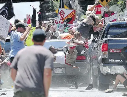  ?? RYAN M. KELLY/THE DAILY PROGRESS VIA AP FILES ?? A vehicle bowls over a group of protesters demonstrat­ing against a white nationalis­t rally Saturday in Charlottes­ville. One woman was killed and 19 others hurt.