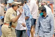  ??  ?? Policeman slaps a customer for disobeying social distancing norms at a wine shop.