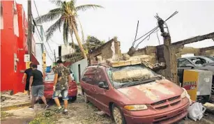  ?? CAROLYN COLE/LOS ANGELES TIMES ?? The day after Hurricane Maria made a direct hit on Puerto Rico, residents of San Juan begin to clean up.