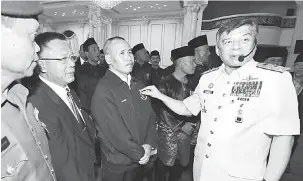  ??  ?? TETAP INGATKA VETERAN: Ahmad Kamarulzam­an ngelekatka Midul Pingat Jasa Malaysia ngagai siku veteran TLDM di Kuching kemari.