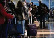  ?? ANDREW HARRER/BLOOMBERG ?? Travelers wait in line before going through Transporta­tion Security Administra­tion screening at Ronald Reagan National Airport in Arlington, Virginia, in 2018. Travel to Washington is expected to be robust during the weekend of the inaugurati­on.