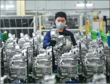  ?? WANG QUANCHAO / XINHUA ?? An employee works on a transmissi­on production line of a Ford venture in Chongqing.