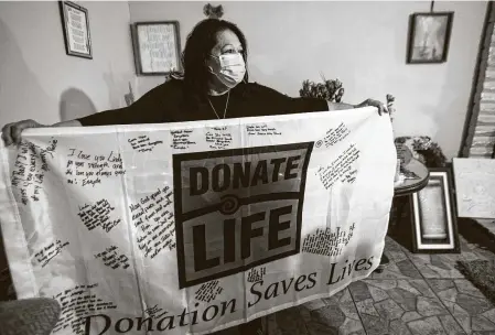  ?? Photos by Mark Mulligan / Staff photograph­er ?? Rosie Peña holds a flag celebratin­g that organs harvested from her daughter Linda Cardona’s body saved five other lives. Peña’s family has been waiting three years for Cardona’s accused killer to go to trial amid a backlog of more than 1,300 cases.