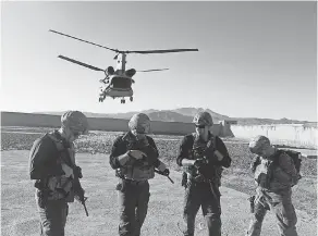  ??  ?? U.S. soldiers take position Thursday as a helicopter lands in Mohammad Agha district of Logar province, Afghanista­n. JAWAD JALALI/EUROPEAN PRESSPHOTO AGENCY