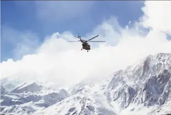  ?? Ali Khodaei / Tasnim News Agency ?? A rescue helicopter searches for wreckage of the Aseman Airlines ATR-72, a twin-engine turboprop that went down in a mountainou­s area of southern Iran. All 65 aboard were killed.