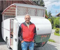  ?? FOTO: TOBIAS SCHUMACHER ?? Norbert Horn mit dem Dethleffs-Wohnwagen Baujahr 1951 (rechts neben ihm das Firmenlogo), den er zurzeit restaurier­t.