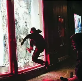 ?? EFE ?? Unos jóvenes destrozan el escaparate de una de las tiendas de Paseo de Gracia
