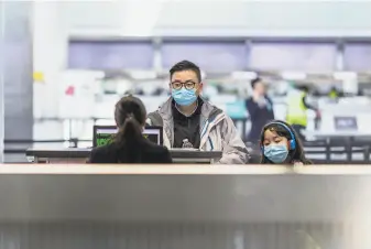  ?? Brian Feulner / Special to The Chronicle ?? Passengers check in Friday at the China Eastern Airlines counter at S.F. Internatio­nal Airport, where most flights to mainland China have been canceled because of coronaviru­s concerns.