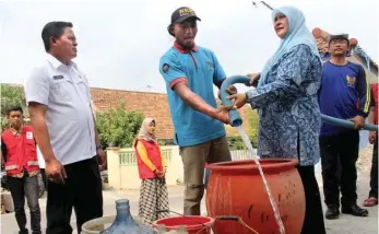  ?? ANWAR BAHAR BASALAMAH/JAWA POS RADAR KEDIRI ?? REALISASI BANTUAN: Adi Sutrisno (kiri) ikut mendamping­i petugas yang mengirim air bersih di Lingkungan Tumpang, Pojok, Mojoroto.