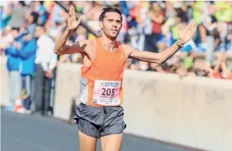  ??  ?? Michalis Kalomiris is seen crossing the finish line of the Athens Marathon at the Panathenai­c Stadium last year.