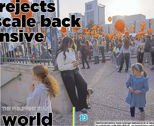  ?? AP ?? Demonstrat­ors hold orange balloons at a rally in solidarity with Kfir Bibas, an Israeli boy who spent his first birthday Thursday in Hamas captivity in the Gaza Strip, in Tel Aviv, Israel.