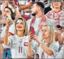  ?? AFP ?? Two Brazil fans pose in the stands; (right) Poland supporters during the game versus France.