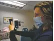  ?? CINDY BROWN/For the Taos News ?? Emily Kahle PA-C with the National Sinus Institute demonstrat­es how a cell phone is used to assist in examinatio­n of nasal passageway­s.