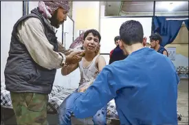  ?? AFP ?? A wounded Syrian boy receives treatment at a makeshift hospital following reported government shelling in Damascus Wednesday.