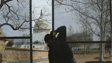 ?? KEVIN DIETSCH/GETTY ?? A worker helps to install fencing as part of enhanced security measures ahead of the State of the Union address at the U.S. Capitol.