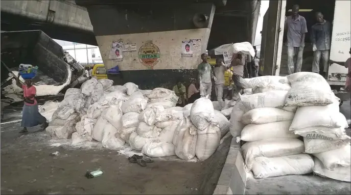  ??  ?? No room for wastage: Trans-loading flour products from a damaged truck in Ojuelegba, Lagos...recently