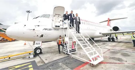  ?? — Photo by Roystein Emmor ?? (From right) Mohamad, Lee and Xing pose for a photo with the ARJ21-700.