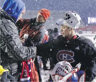  ?? JANA CHYTILOVA/GETTY IMAGES/FREESTYLE PHOTO ?? Habs goalie Carey Price signs an autograph for a young fan after practice at Lansdowne Park on Friday. Price will unveil a new goalie mask made specially for the outdoor game, but says he won’t wear a tuque, even with bonechilli­ng temperatur­es in the...