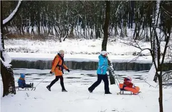  ?? Reuters ?? Women pull children on sledges in a park in Minsk, Belarus. The country is targeting growth in tourism through a raft of friendly policies.