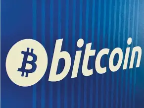  ??  ?? Virtual plunge: A bitcoin logo is seen on a cryptocurr­ency ATM in Santa Monica, California, in the US. VersaBank is building its vault as bitcoin plunged below US$7,000 on Monday for the first time since November. —