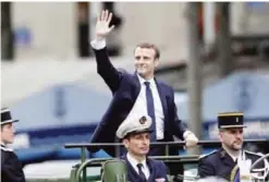 ??  ?? In this May 14, 2017 file photo, new French President Emmanuel Macron waves to the crowds as he is transporte­d up the Champs-Elysees Avenue after his inaugurati­on ceremony in Paris. — AP