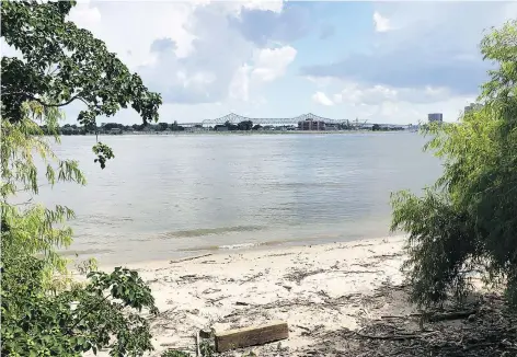  ??  ?? At Crescent Park, part of New Orleans’ riverfront developmen­t, trail users pass a sliver of beach on the Mississipp­i River.