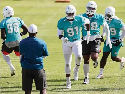  ?? AL DIAZ adiaz@miamiheral­d.com ?? Defensive end Emmanuel Ogbah (91) leads fellow lineman Raekwon Davis and other defenders through warmups Friday. The highly-rated Dolphins defense will face its toughest test of the season Sunday against Patrick Mahomes and the Chiefs.