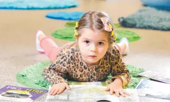  ?? Picture: Steve Pohlner ?? STORYBOOK COLLECTION: Lo Sandstrsm, aged three, loves reading. Australia's bookworms are getting younger and younger with libraries reporting a rise in attendance at under 5s reading times.