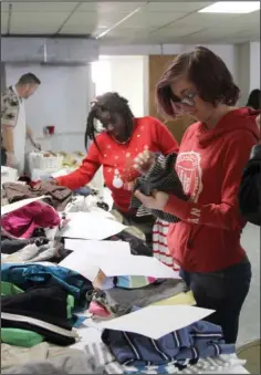  ?? The Sentinel-Record/Grace Brown ?? WARM CLOTHES: Betty Brunt, left, and Raven Cole search through the winter clothing section at “A Thanksgivi­ng to Share” on Thursday at Visitor’s Chapel AME Church, 319 Church Street. Coats, meals and fellowship were made available to those finding...