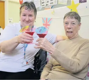  ??  ?? ●●Volunteer Kath Bake shares her ‘mocktails’ with patient Marion Smith