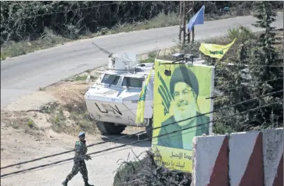  ??  ?? HOĆE LI UN POMOĆI? Pokraj plakata koji prikazuje vođu Hezbollaha Hassana Nasrallaha na granici dvije zemlje šeću vojnici UN-a (gore), a na izraelskoj je strani granice proturaket­no oružje (dolje)