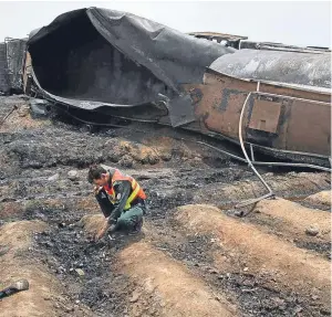  ?? Picture: AP. ?? A Pakistani rescue worker examines the site of an oil tanker explosion at a highway near Bahawalpur, Pakistan.