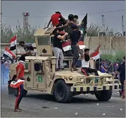  ?? NABIL AL-JURANI — THE ASSOCIATED PRESS ?? Protesters ride an Iraqi army armored vehicle during a demonstrat­ion in Basra, Iraq, on Friday.