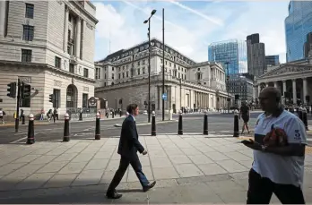  ?? — Bloomberg ?? Potential distress: City workers passing by the BOE in London. UK homeowners’ exposure to floating rate mortgages and vulnerabil­ity to rising unemployme­nt will make the British market a potential outlier amid the twin hits of rising BOE rates and this week’s expected fiscal squeeze.