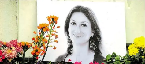  ?? DPA-BILD: KLIMKEIT ?? Blumen stehen vor einem Foto der ermordeten Journalist­in Daphne Caruana Galizia in Valletta.