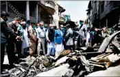  ?? PTI ?? In this photo released by Pakistan Civil Aviation Authority, provincial governor Imran Ismail, center, in blue coat, and Pakistan’s aviation minister Ghulam Sarwar, center in black waistcoat, visit the site of Friday’s plane crash, in Karachi, Pakistan on Saturday