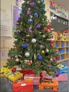  ?? ?? Decorated shoeboxes filled with Christmas presents sit under the tree in the Lorain County JVS Early Childhood Education classroom.