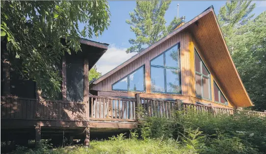  ?? PHOTOS: PERRY MASTROVITO ?? The large windows on the A-frame façade offer a spectacula­r view of the lake and forest, as well as let in plenty of light and passive heat.