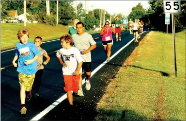  ?? Photo by Mike Eckels ?? Contestant­s in the 5K-10K ran along State Highway 102 during the Decatur Barbecue on Aug. 1, 2015. The 2016 event starts at 7 a.m. from the concession stands at Edmiston Park In Decatur.