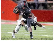  ?? Arkansas Democrat-Gazette/THOMAS METTHE ?? Arkansas State running back Marcel Murray (34) tries to break away from an attempted tackle by Appalachia­n State defensive back Josh Thomas during Tuesday night’s game.