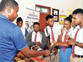  ??  ?? Students from Kemps Hill High School in Clarendon sample different types of oranges on display at the Bodles Research Station in St Catherine, during the Citrus Day Exhibition on March 2. The students are being served by greenhouse manager at Bodles,...